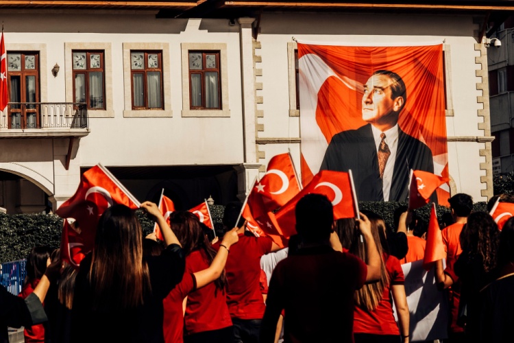 Mustafa Kemal Atatürk'ün bir portresi ve dalgalanan Türk bayrağı